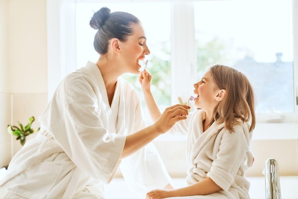 Dental care for kids - a mom and daughter brushing their teeth together