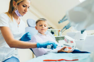 Alt Tag: Dentist teaching a child about the importance of early dental visits.