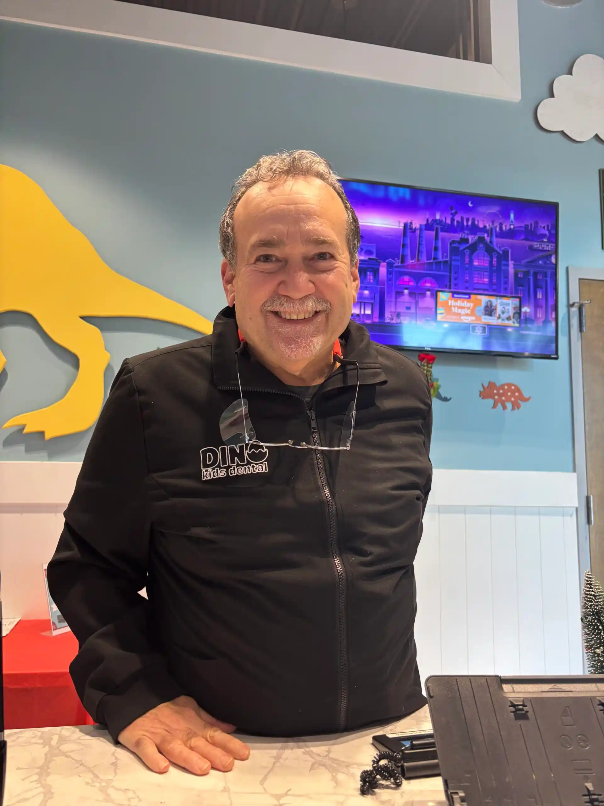 Dr. Carlos Garcia Soto, experienced pediatric dentist at Dino Kids Dental, smiling in his office